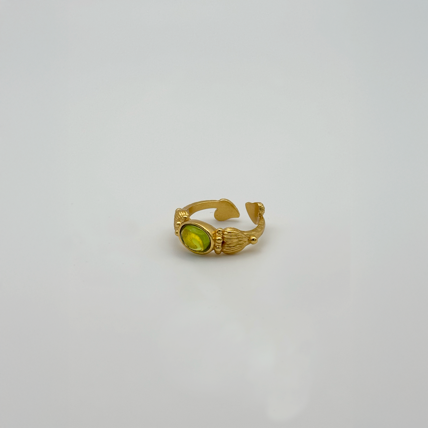 The Details: The band itself is a work of art, featuring a rich, matte-gold texture that mimics organic plant life. On either side of the central green stone, the band ends in two sweet golden hearts, creating a romantic "wrap" effect on your finger. The vivid green stone acts as a bright focal point, catching the light beautifully from every angle.